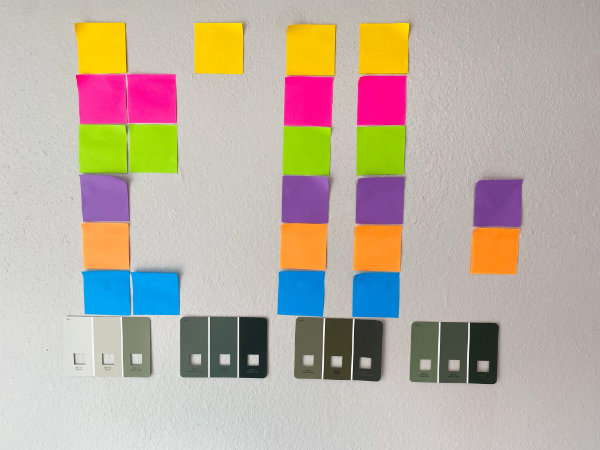 Sticky notes posted to a wall with corresponding paint swatches