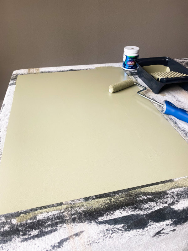Painted board with a paint roller sitting on top