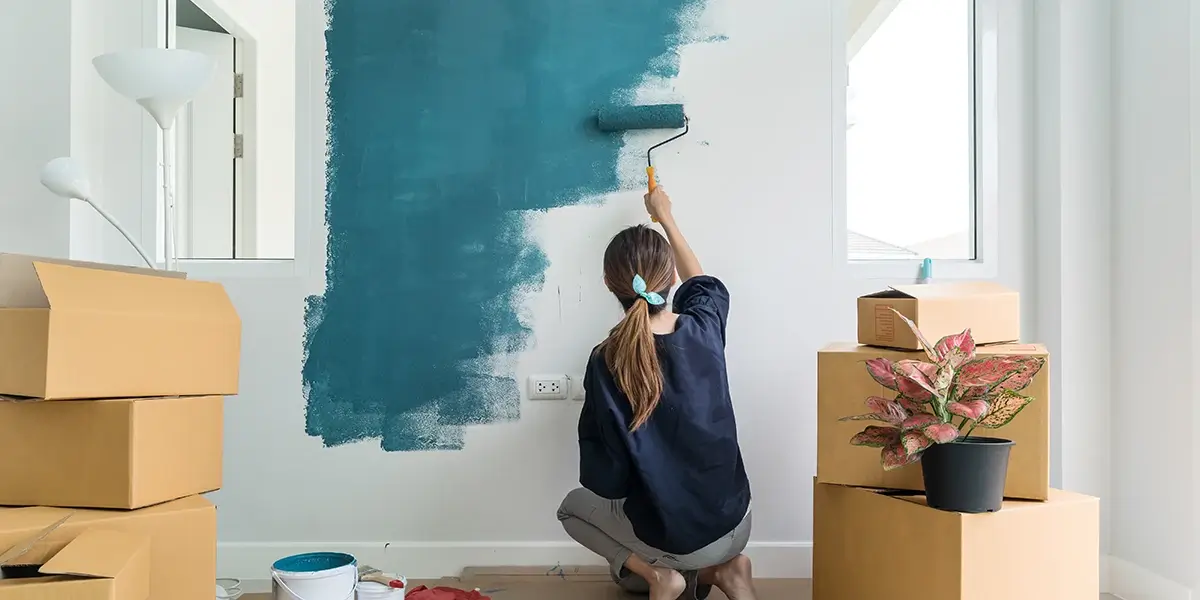 A woman painting a wall in a new home.