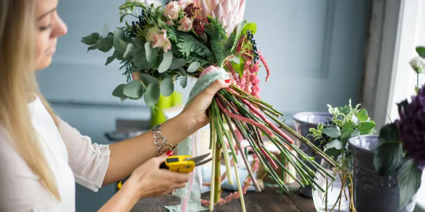 A home gardener prepares flowers for a vase arrangement