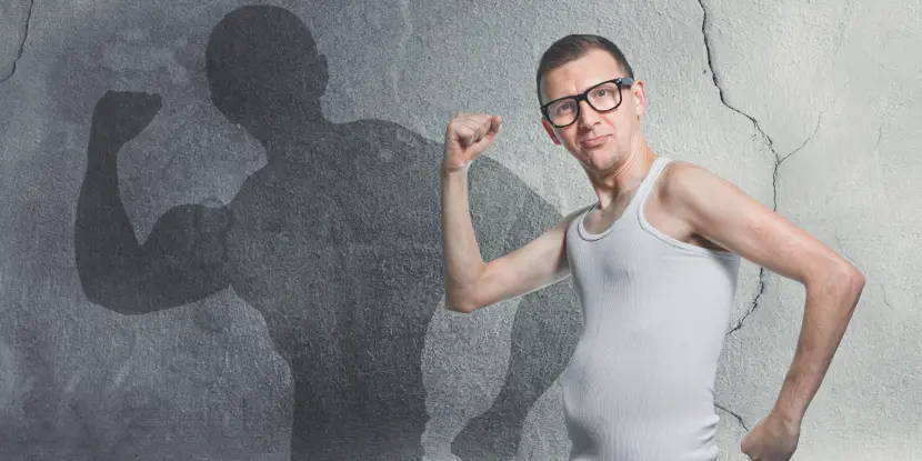 Skinny man posing as a bodybuilder