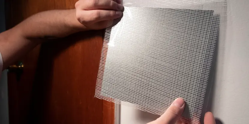 Applying screen mesh to a hole in the wall