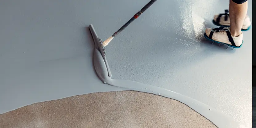 Man painting a garage floor with epoxy