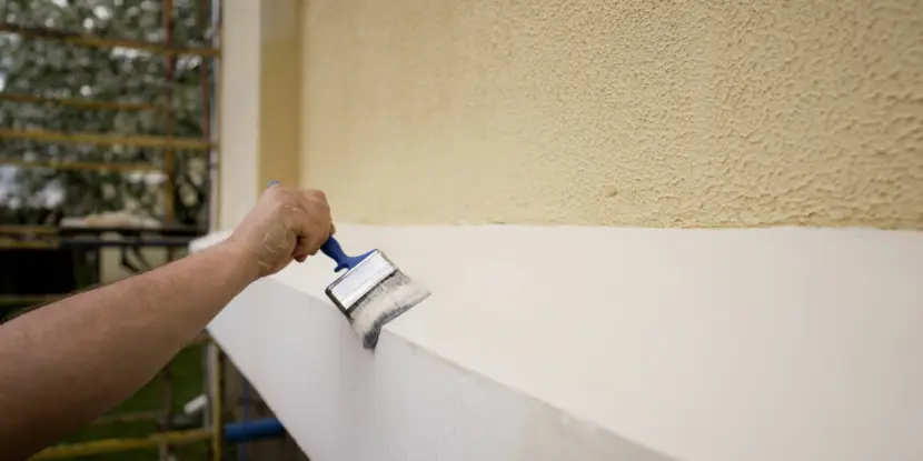 A man painting a home's exterior