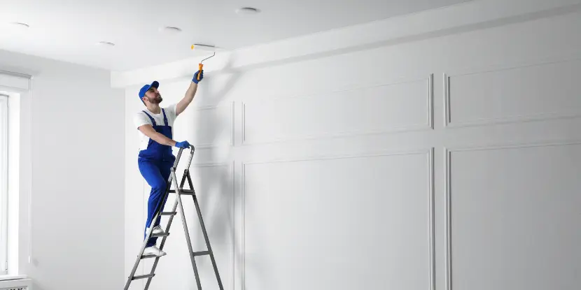 A man painting a ceiling