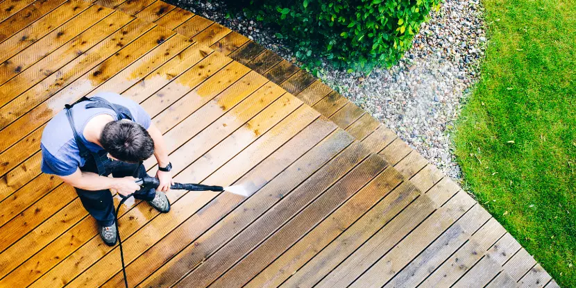 A man power washing his deck