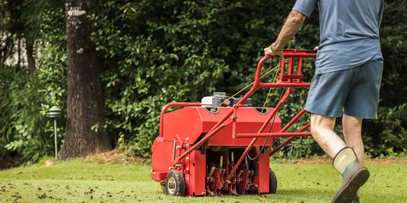 A man aerating his lawn