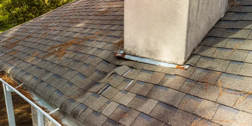 An asphalt roof with structural damage