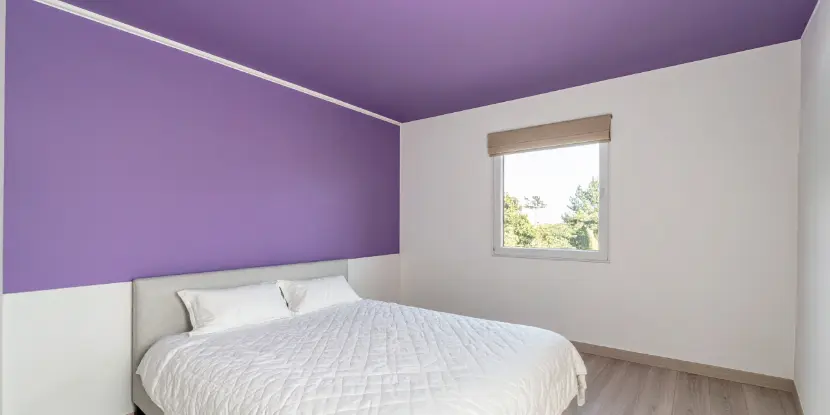 A bedroom with a purple ceiling