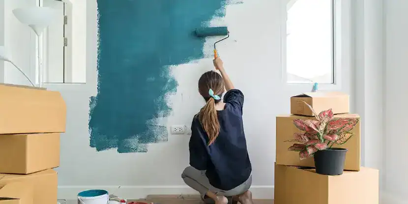A woman painting a wall