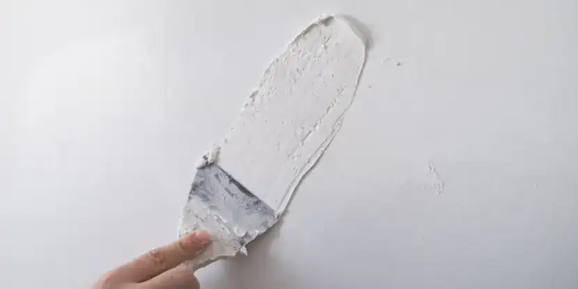 A painter applying spackle