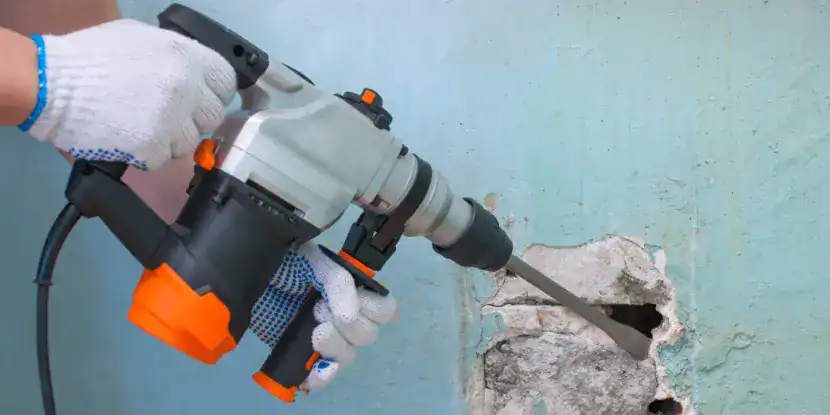 A hammer drill being used as a small jackhammer