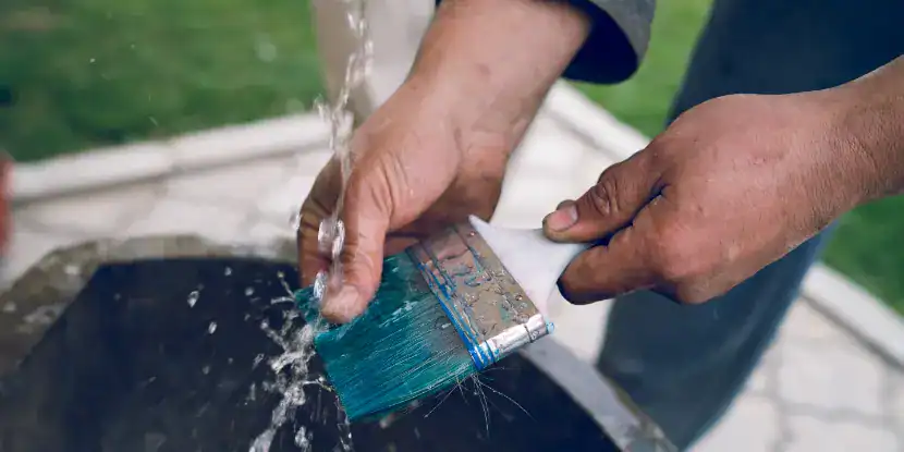 A man washes a paintbrush