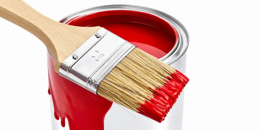A bristle paintbrush loaded with red paint