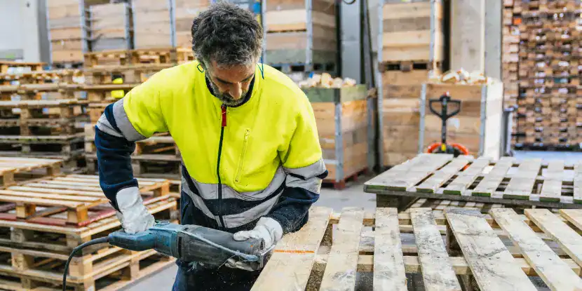 A worker cuts a palette