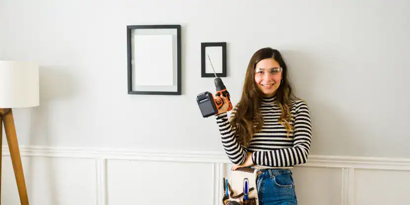 A woman hangs pictures