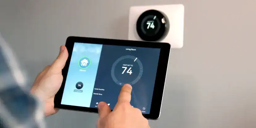 A homeowner changes the settings of a smart thermostat