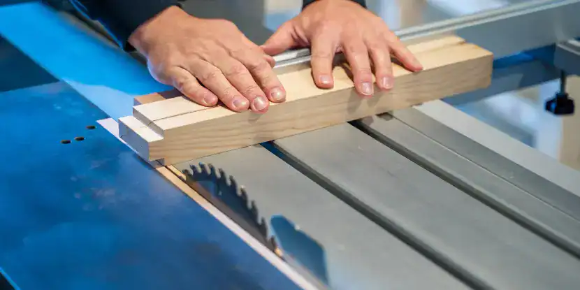 A woodworker uses a guide rail to secure his cut