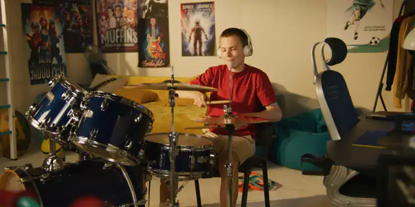 A teenager practices drumming